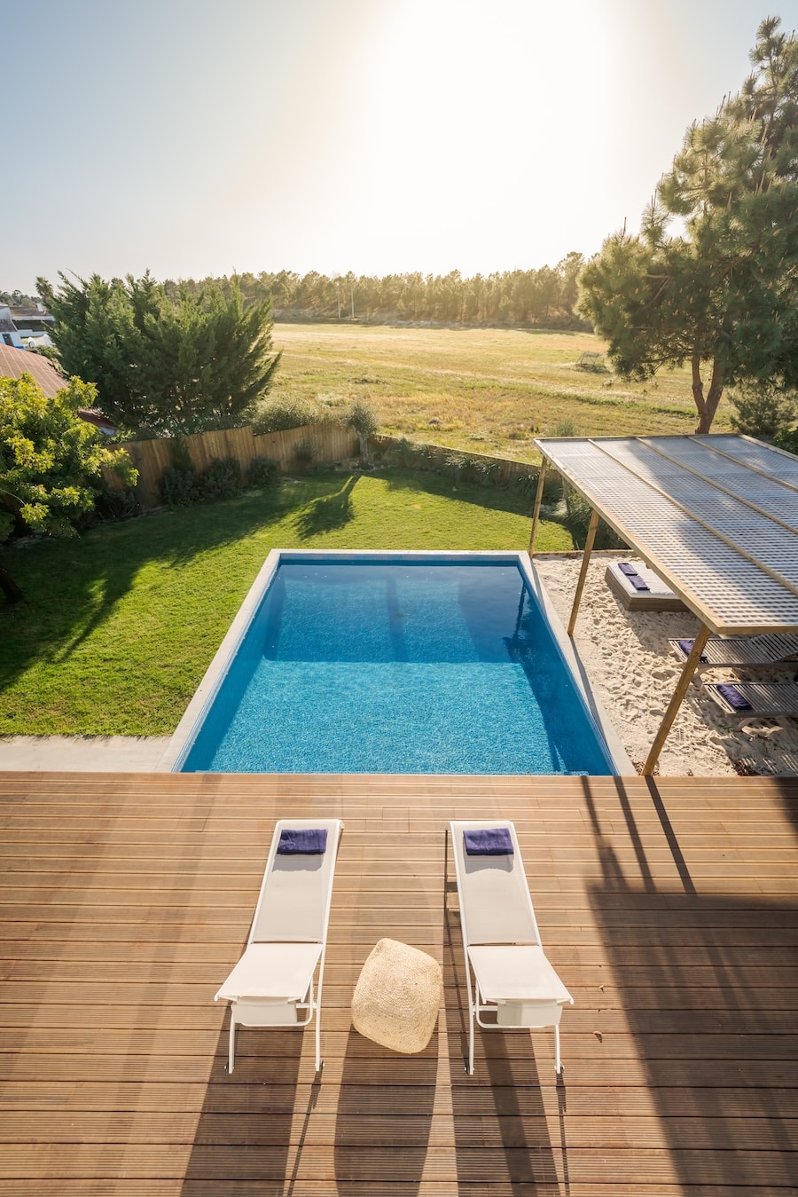 Modern gestalteter Garten mit Pool, Holzdeck und Rasenfläche im privaten Außenbereich