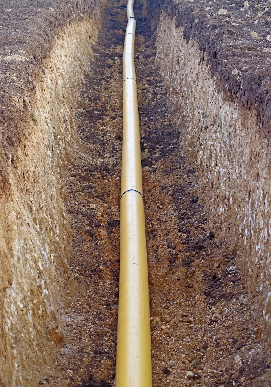 Verlegte Rohrleitung in schmalem Graben als Motiv für Grabenbau und Tiefbauarbeiten